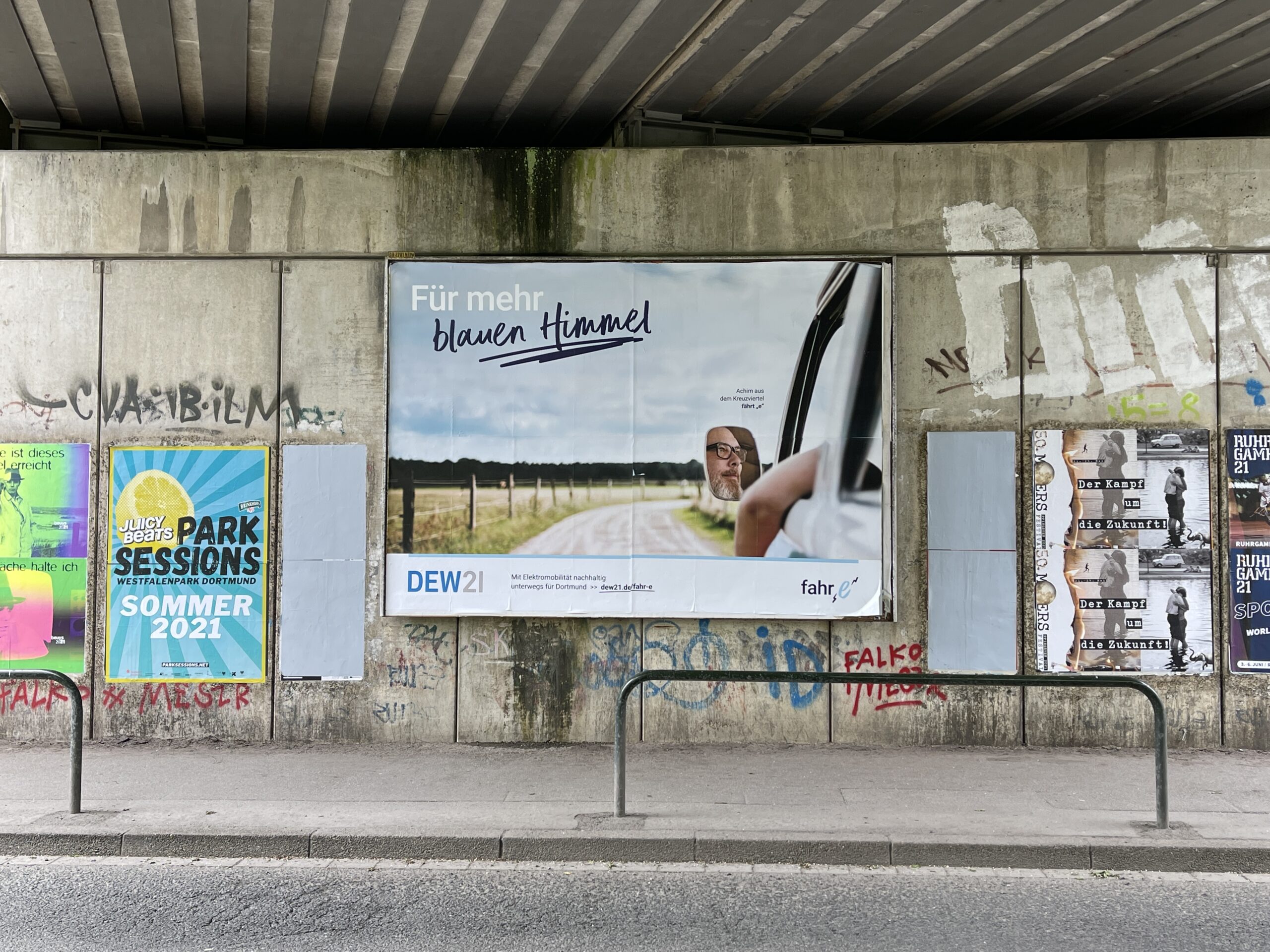 DEW21 Fahr-E-Kampagnenmotiv mit Achim Hepp zwischen weiteren Werbeplakaten in Dortmund